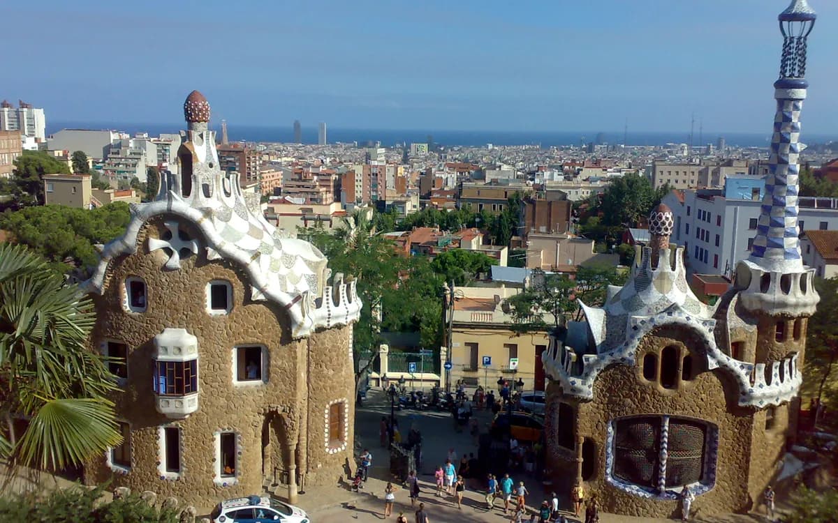 Park Güell'in mozaik kaplı giriş köşkleri ve arkada şehir