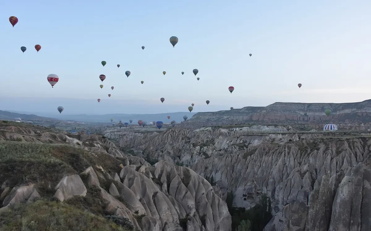 Şafakta Göreme vadilerinin üstünde sıcak hava balonları